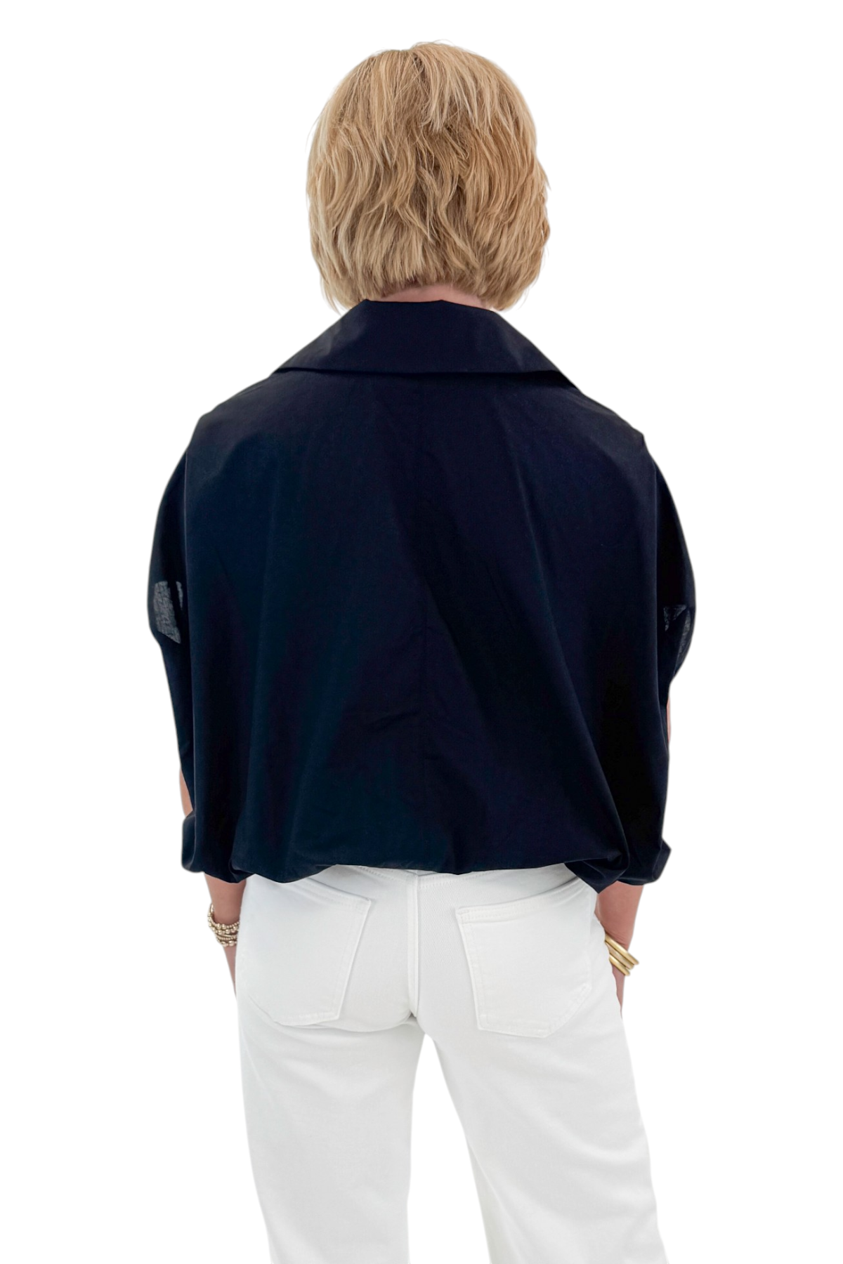 Back view of woman wearing Swagger Boutique’s Black Collared Bubble Hem Top with jeans against white studio background.
