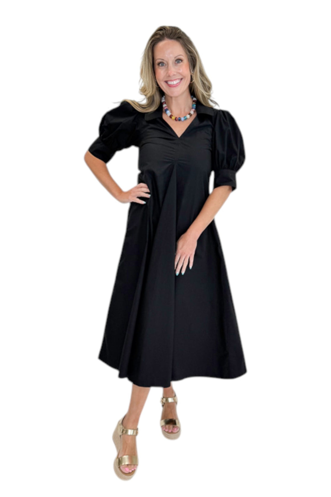 Front view of woman wearing Swagger Boutique’s Black Collared Midi Dress with sandals against white studio background.