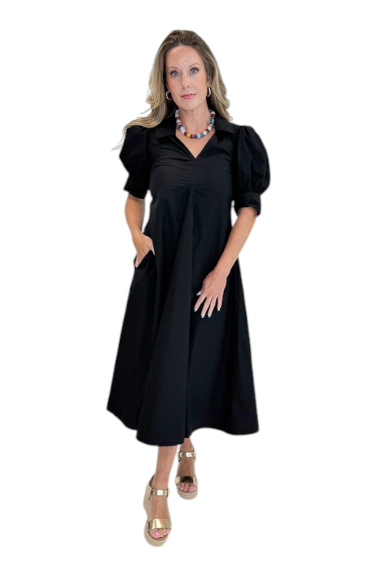 Front view of woman wearing Swagger Boutique’s Black Collared Midi Dress with sandals against white studio background.