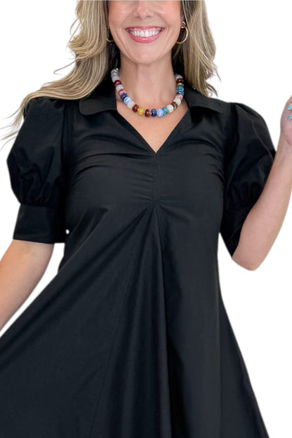 Front detail view of woman wearing Swagger Boutique’s Black Collared Midi Dress with sandals against white studio background.