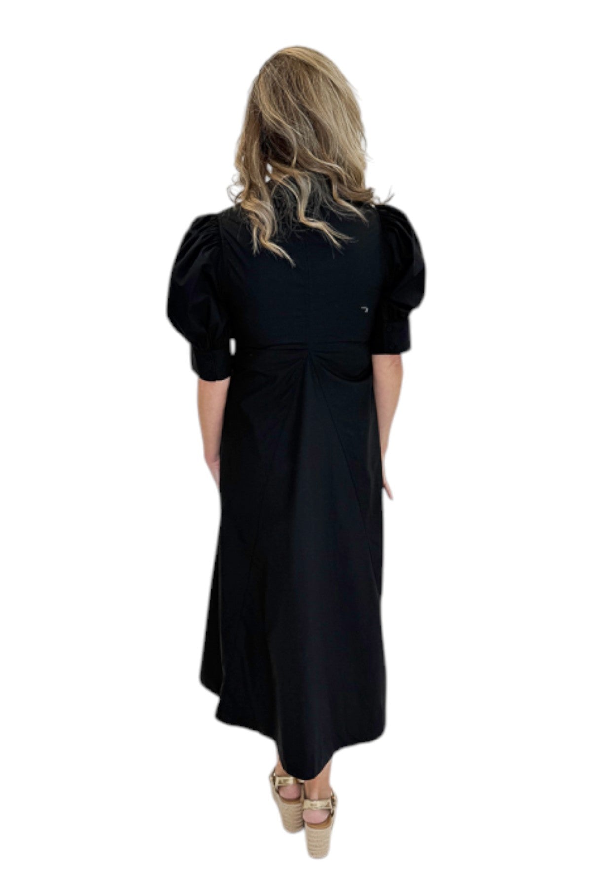 Back view of woman wearing Swagger Boutique’s Black Collared Midi Dress with sandals against white studio background.