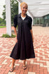 Front view of woman wearing Swagger Boutique’s Black Collared Midi Dress outside by a red brick walkway.