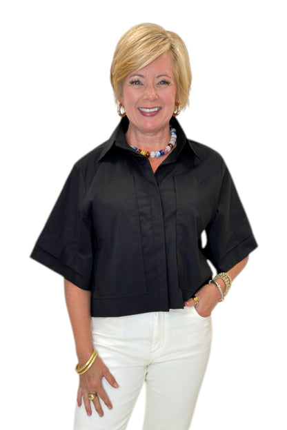 Front view of woman wearing Swagger Boutique’s Black Collared Short Sleeve Top with jeans against white studio background.