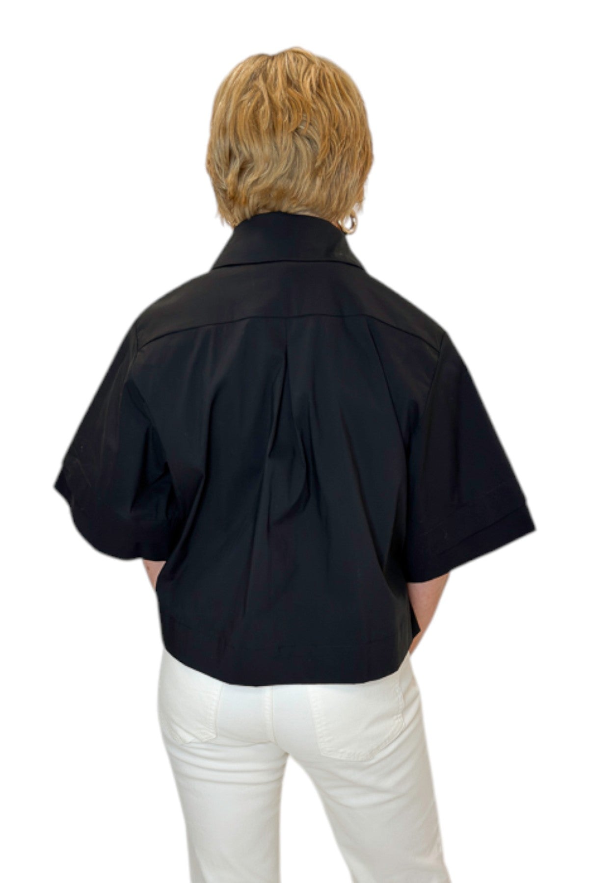Back view of woman wearing Swagger Boutique’s Black Collared Short Sleeve Top with jeans against white studio background.