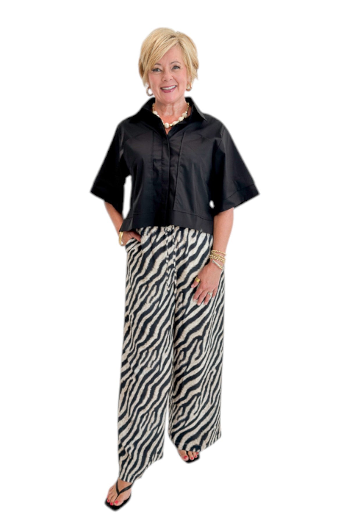 Front view of woman wearing Swagger Boutique’s Black Collared Short Sleeve Top with Zebra Wide Leg Pants by Entro against white studio background.