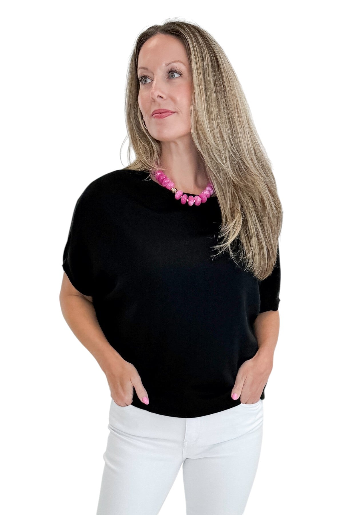 Front view of woman wearing Swagger Boutique’s Black Dolman Sleeve Top with jeans against white studio background.