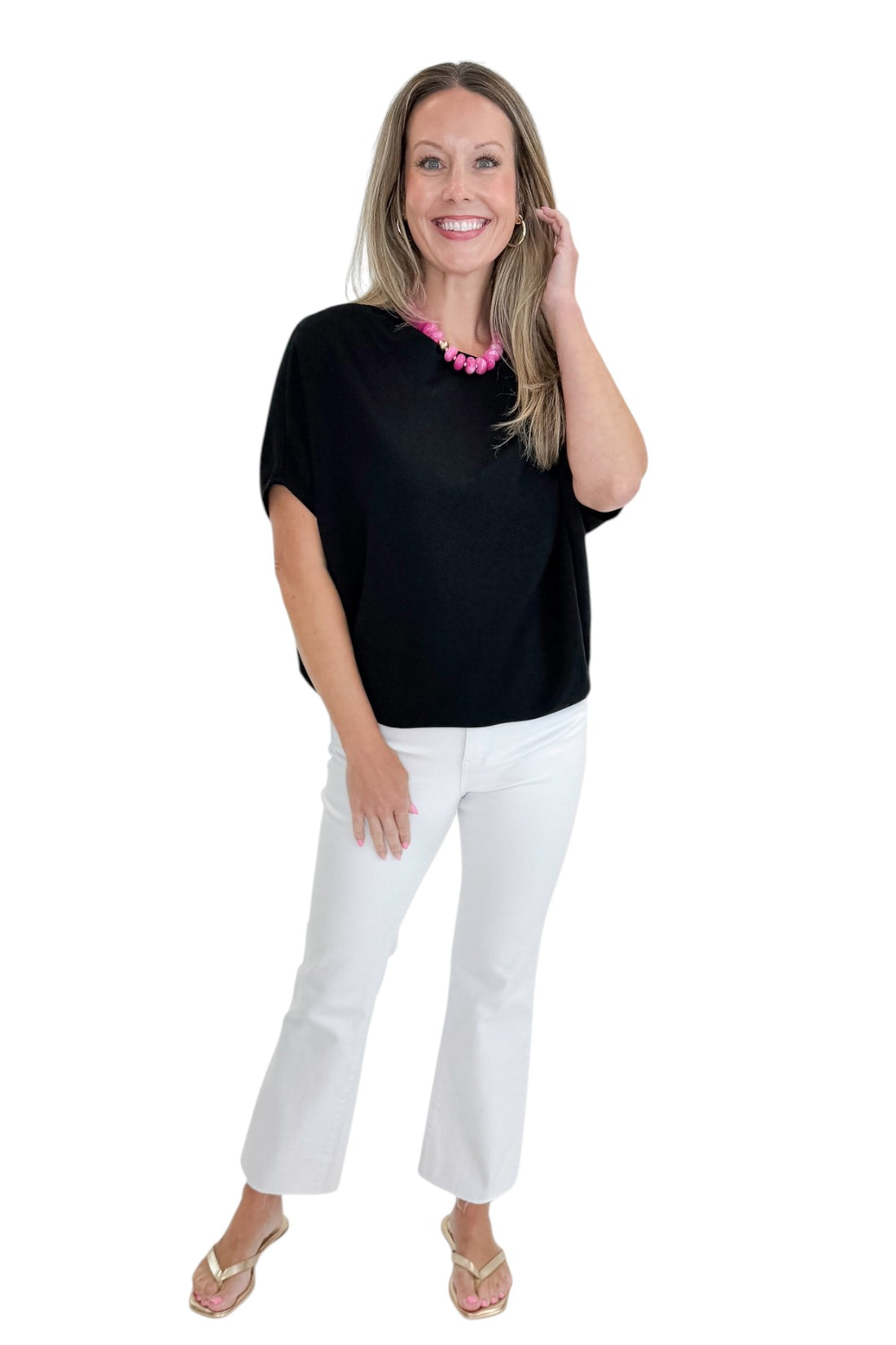 Front view of woman wearing Swagger Boutique’s Black Dolman Sleeve Top with jeans against white studio background.