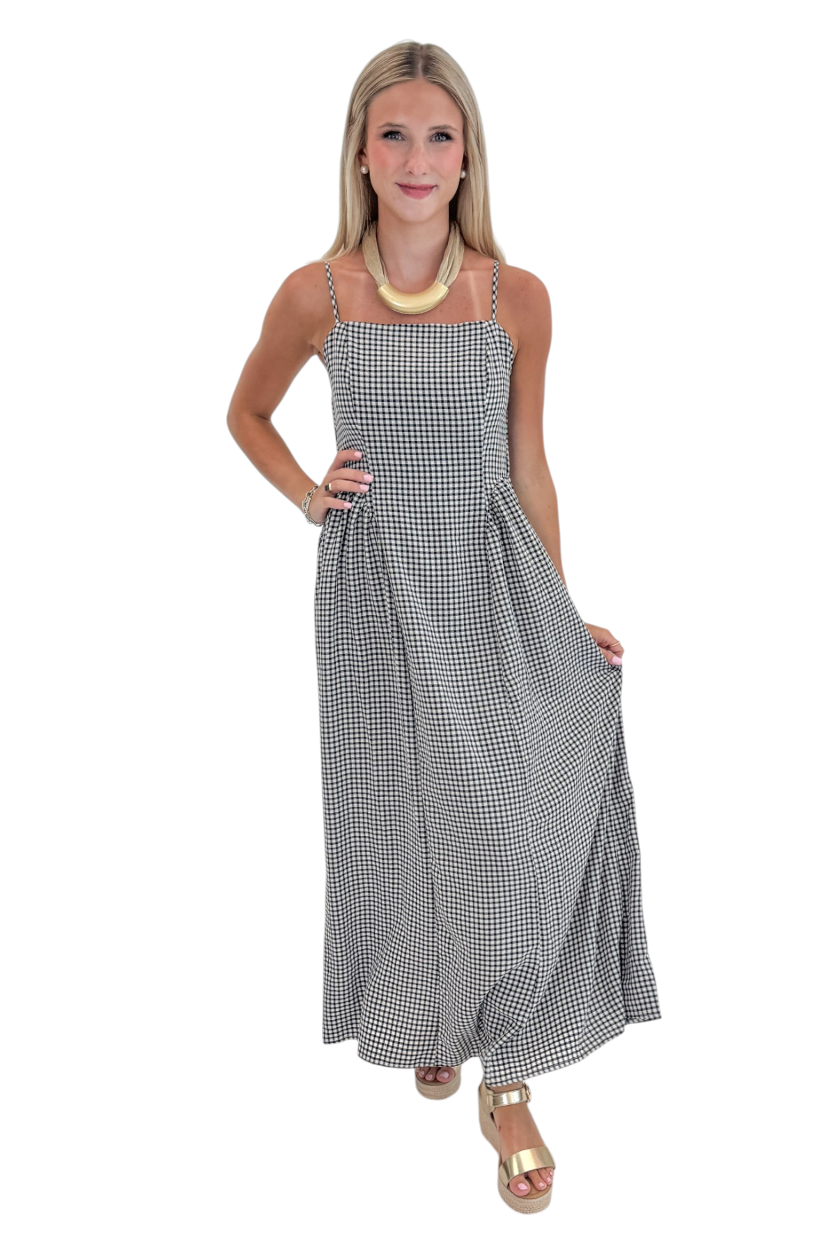 Front view of woman wearing Swagger Boutique’s Black Gingham Maxi Dress with sandals against white studio background.