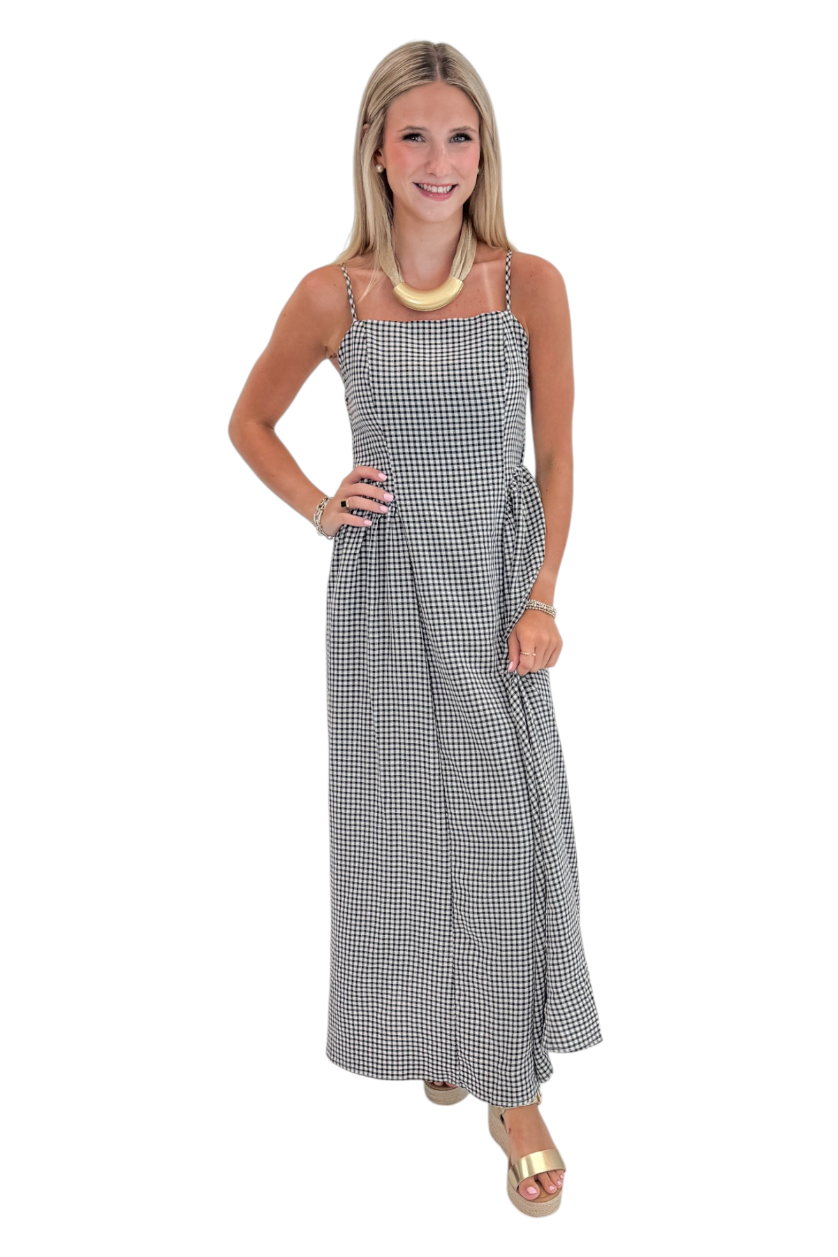 Front view of woman wearing Swagger Boutique’s Black Gingham Maxi Dress with sandals against white studio background.