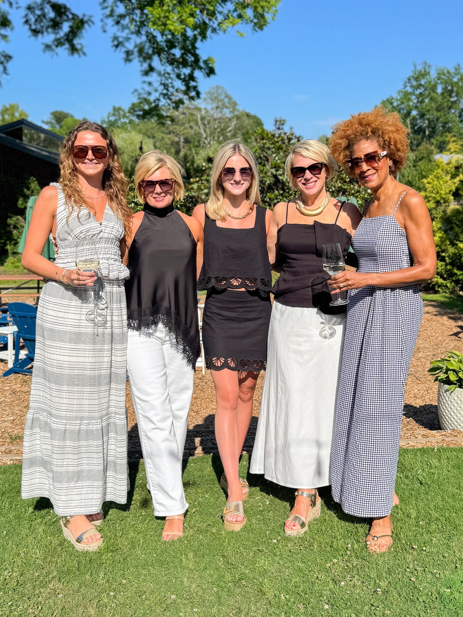 Front view of woman wearing Swagger Boutique’s Black Gingham Maxi Dress with women wearing Charlene Z Supply Set and various other new arrivals.
