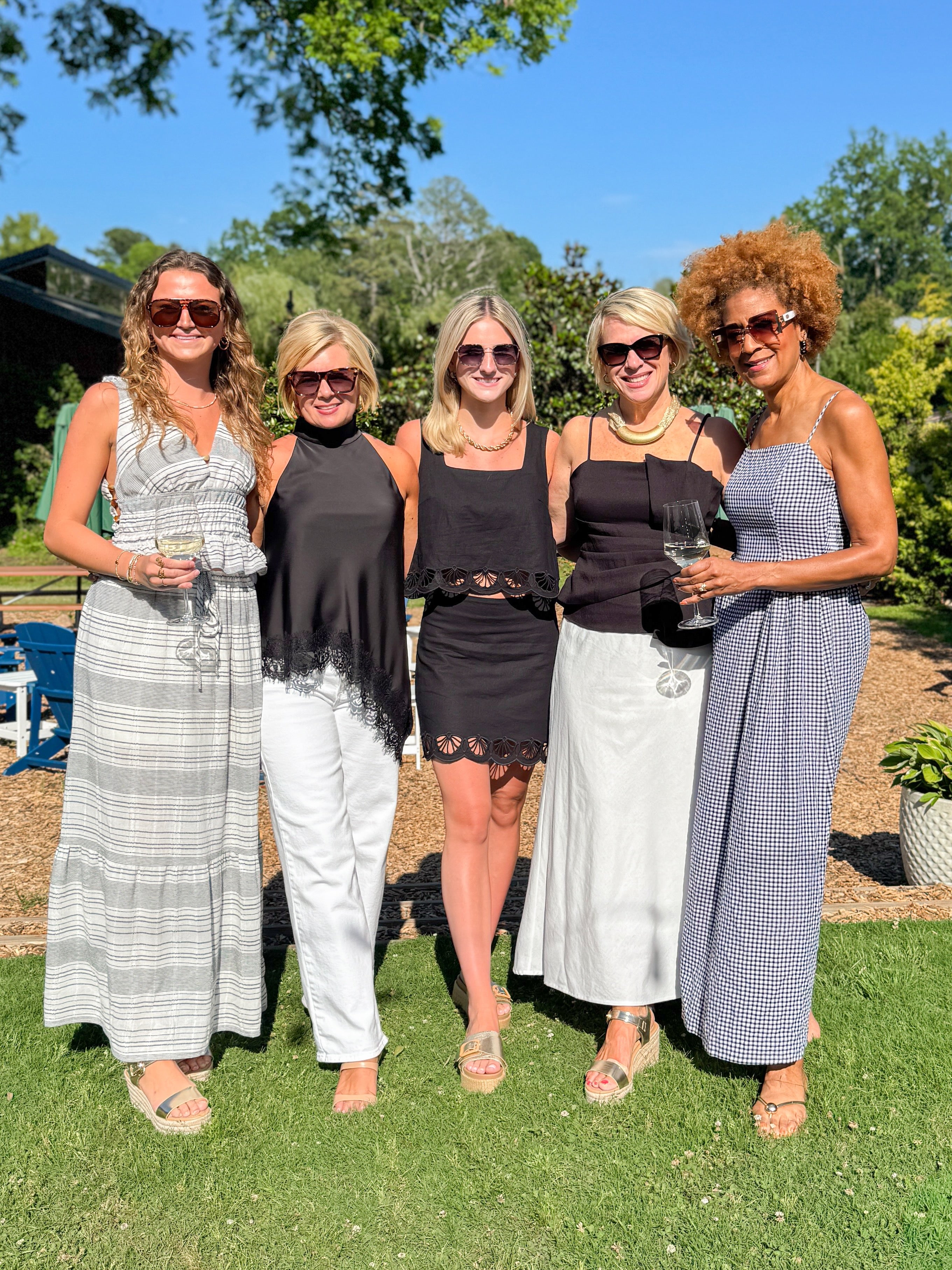 Front view of woman wearing Swagger Boutique’s Black Gingham Maxi Dress with women wearing Charlene Z Supply Set and various other new arrivals.