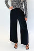 Front detail view of woman wearing Swagger Boutique’s Black High Waisted Trousers by Skies Are Blue & Zebra Mock Neck Long Sleeve Top by Entro against white studio background.