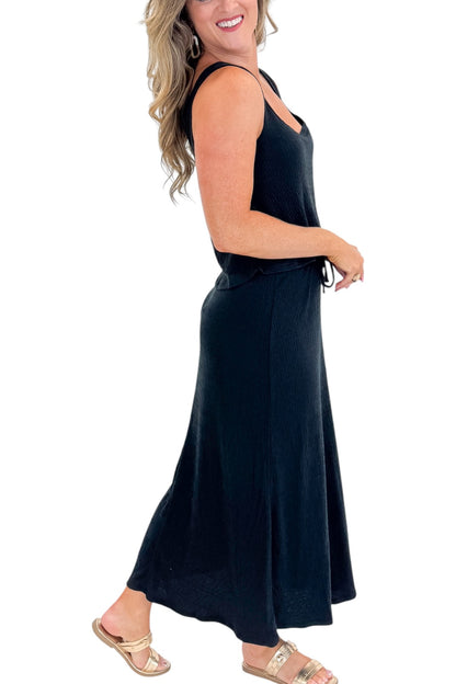 Side detail view of woman wearing Swagger Boutique’s Black Joanna Tank by Z Supply with Black Idris Maxi Skirt by Z Supply against white studio background.
