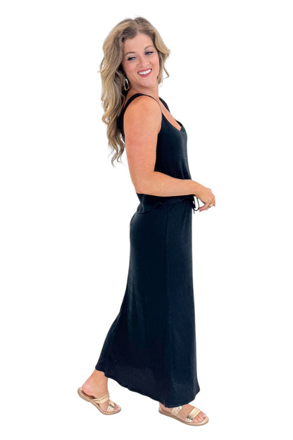 Side view of woman wearing Swagger Boutique’s Black Joanna Tank by Z Supply with Black Idris Maxi Skirt by Z Supply against white studio background.