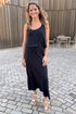 Front view of woman wearing Swagger Boutique’s Black Joanna Tank by Z Supply with Black Idris Maxi Skirt by Z Supply standing outside on a brick pathway.