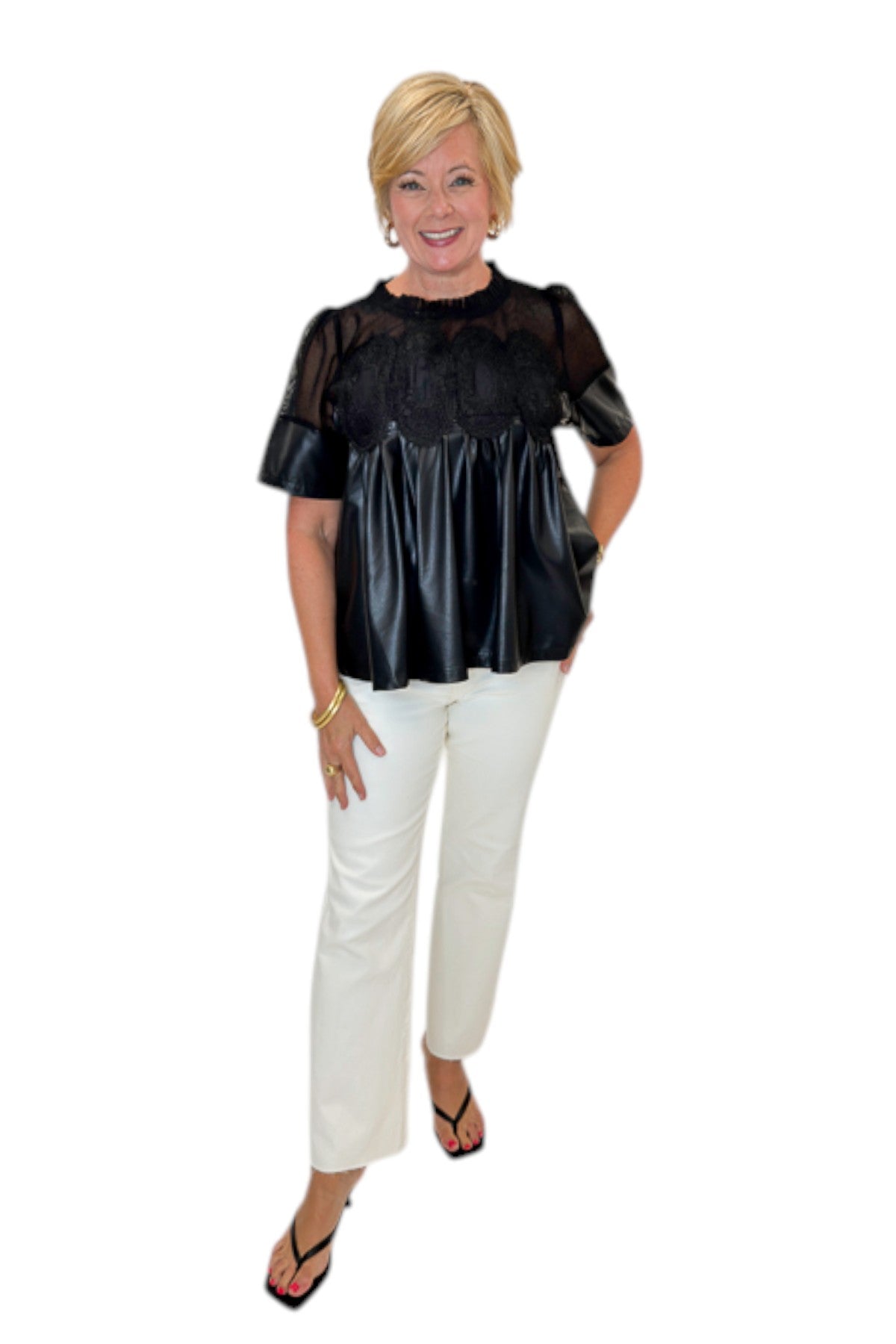 Front view of woman wearing Swagger Boutique’s Black Lace Applique Faux Leather Top with jeans against white studio background.