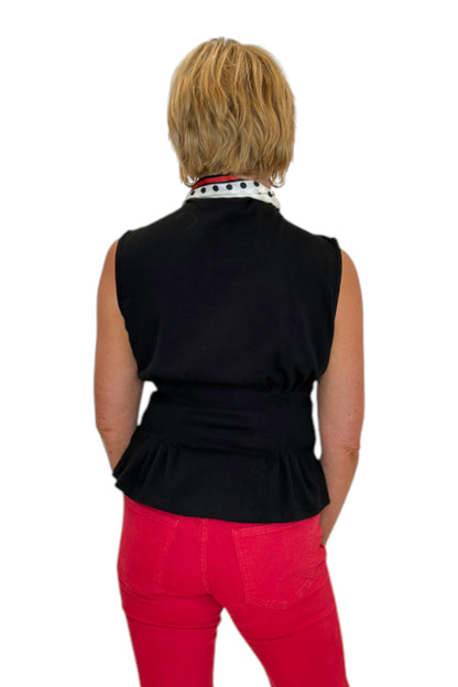 Back view of woman wearing Swagger Boutique’s Black Mock Neck Pleat Waist Top by Entro with skirt against white studio background.