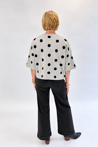 Back view of woman wearing Swagger Boutique’s Black Pintuck Jeans by Risen with sweater against white studio background.