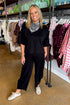 Front view of woman wearing Swagger Boutique’s Black Round Neck Short Sleeve Top with matching barrel pants at the store.