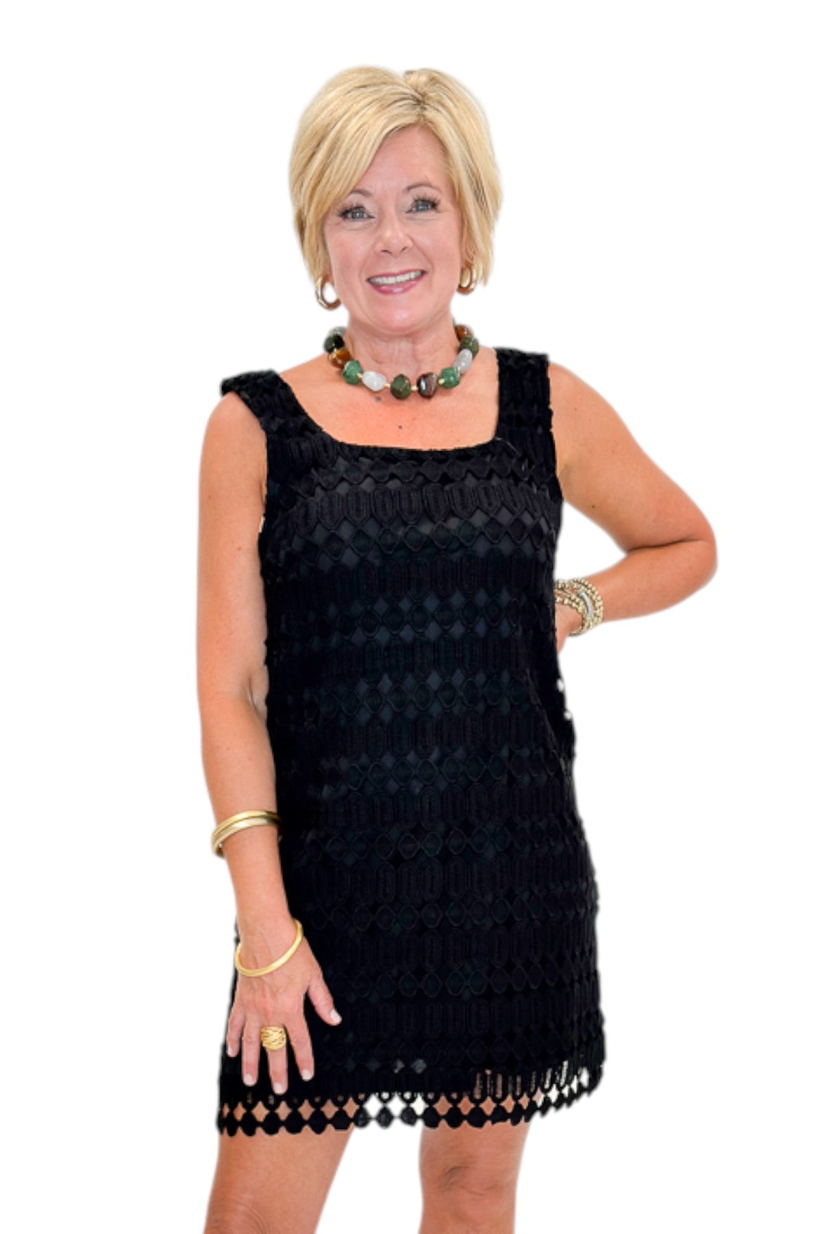 Front view of woman wearing Swagger Boutique’s Black Sleeveless Lace Mini Dress by Entro with heels against white studio background.
