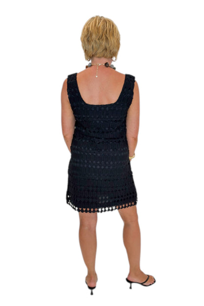 Back view of woman wearing Swagger Boutique’s Black Sleeveless Lace Mini Dress by Entro with heels against white studio background.