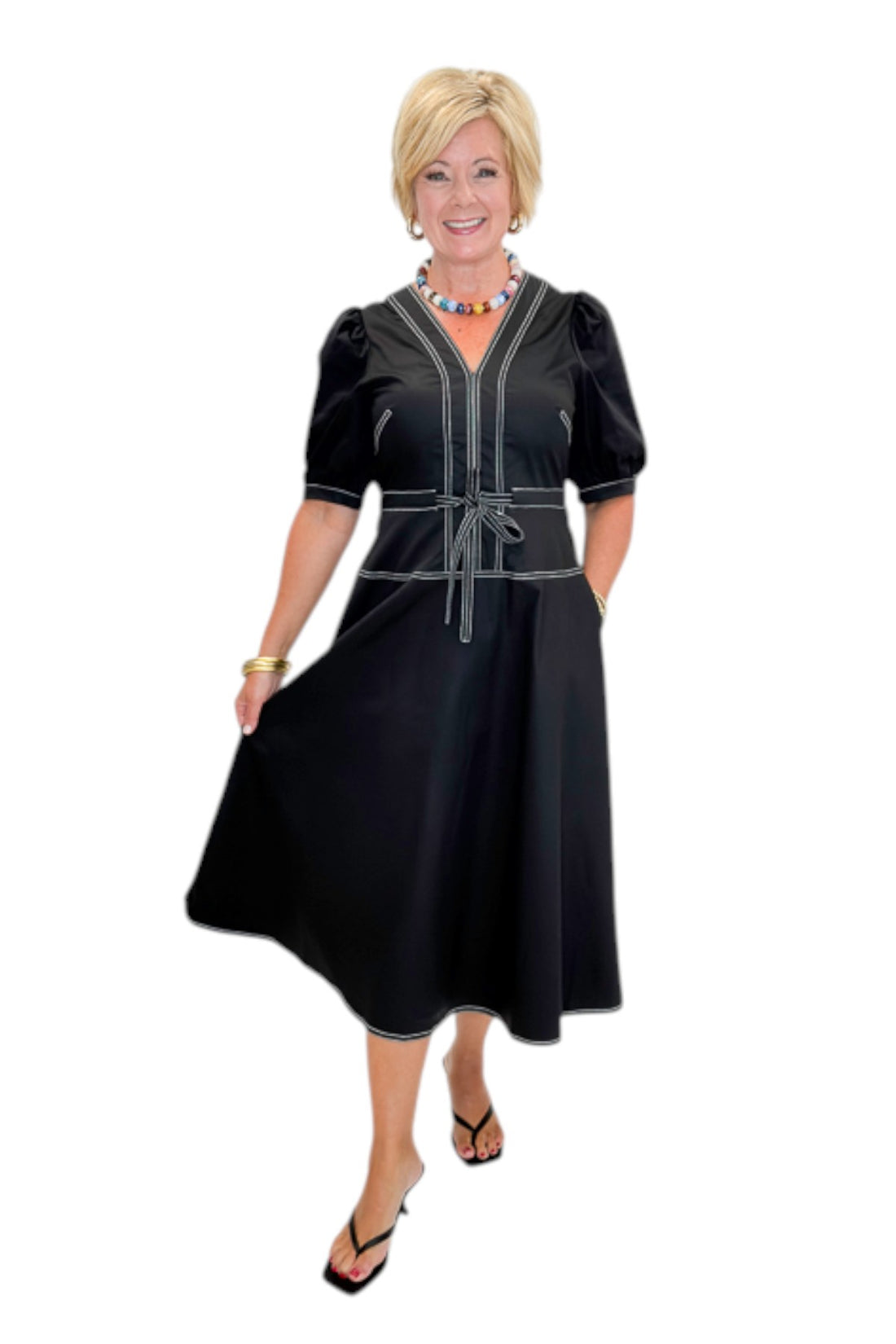 Front view of woman wearing Swagger Boutique’s Black Stitch Midi Dress with heels against white studio background.