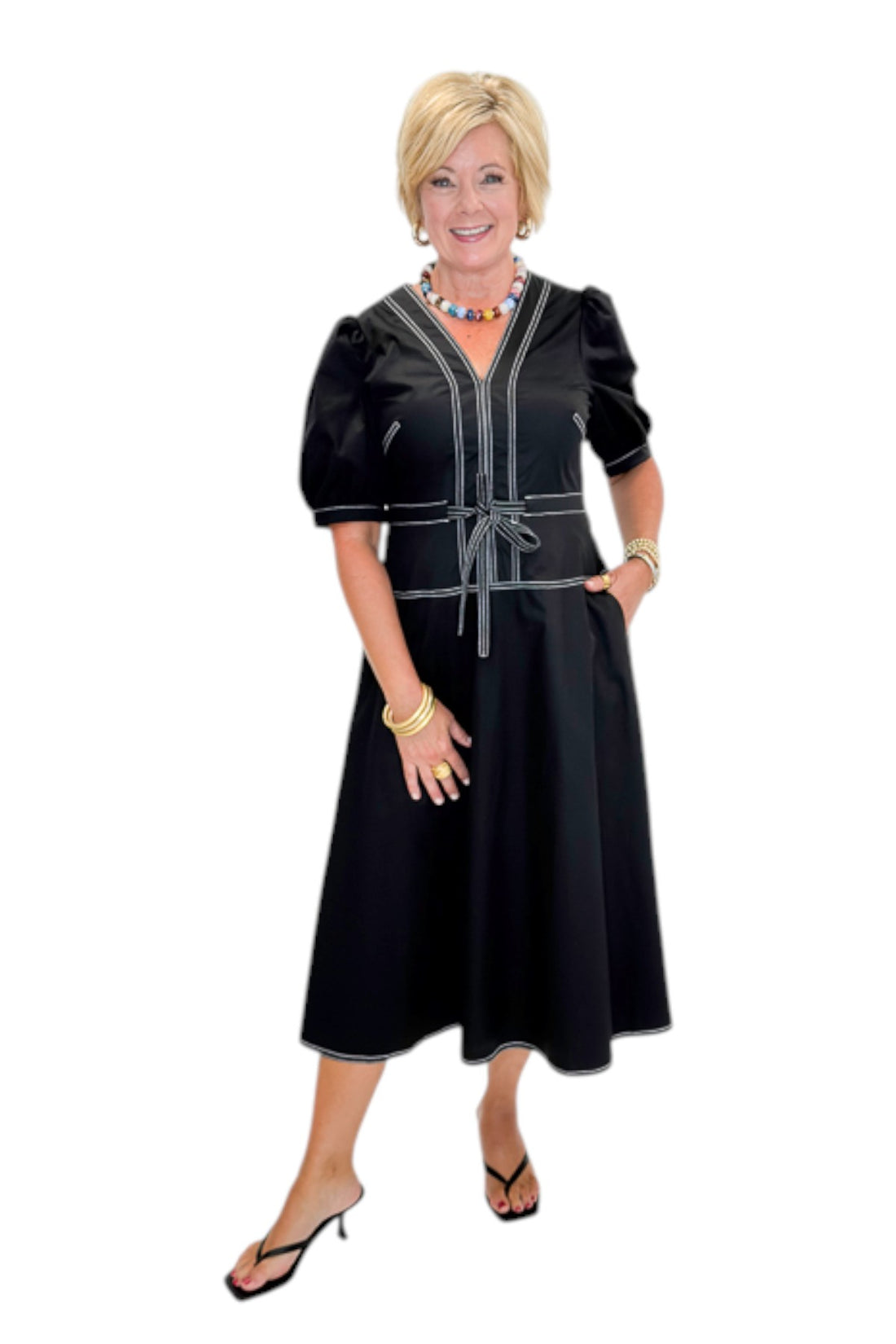 Front view of woman wearing Swagger Boutique’s Black Stitch Midi Dress with heels against white studio background.