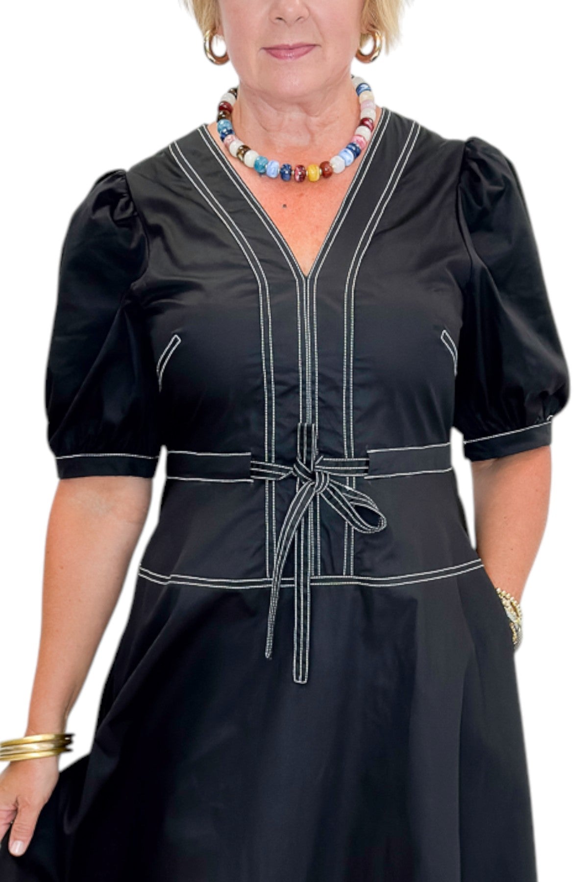 Front detail view of woman wearing Swagger Boutique’s Black Stitch Midi Dress with heels against white studio background.