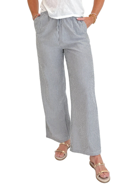 Front detail view of woman wearing Swagger Boutique’s Black Striped Wide Leg Pants with Junie White Tee by Z Supply against white studio background.