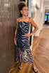 Front view of woman wearing Swagger Boutique’s Black Zebra Maxi Dress with heels standing at an Art Gallery. 