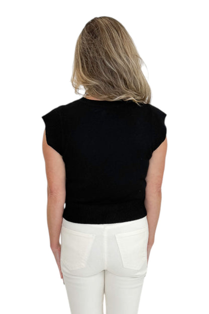 Back view of woman wearing Swagger Boutique’s Black Cap Sleeve Sweater with jeans against white studio background.