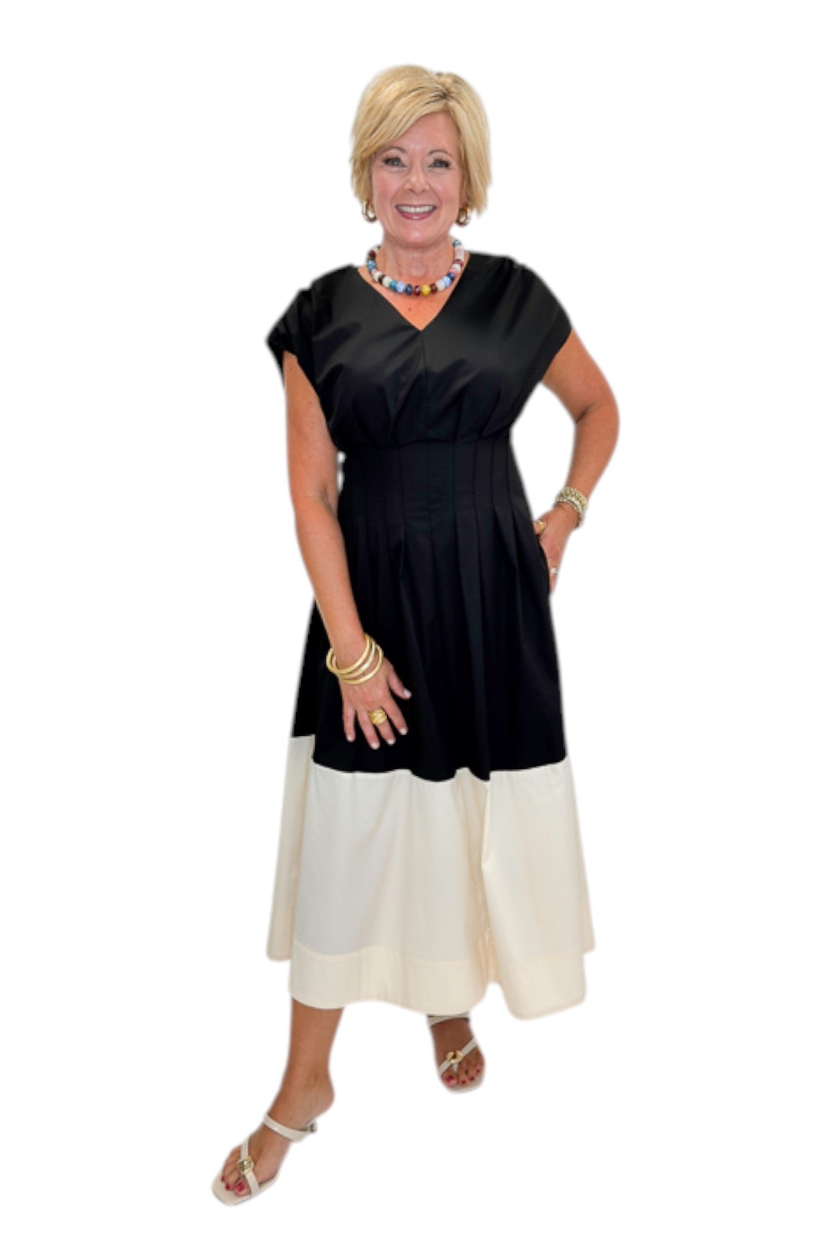 Front view of woman wearing Swagger Boutique’s Black &amp; Cream Color Block Midi Dress by Entro with sandals against white studio background.