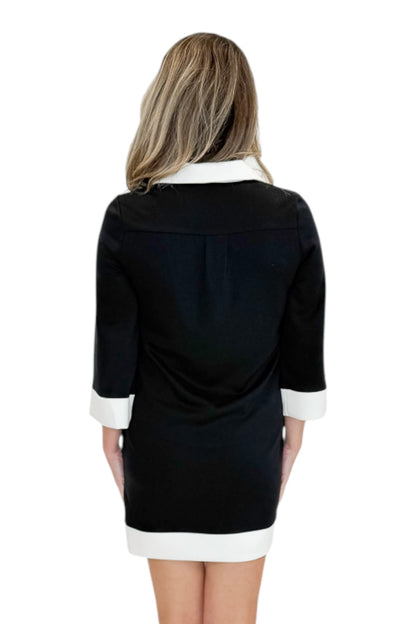 Back view of woman wearing Swagger Boutique’s Black &amp; Cream Color Block Shift Dress with sandals against white studio background.