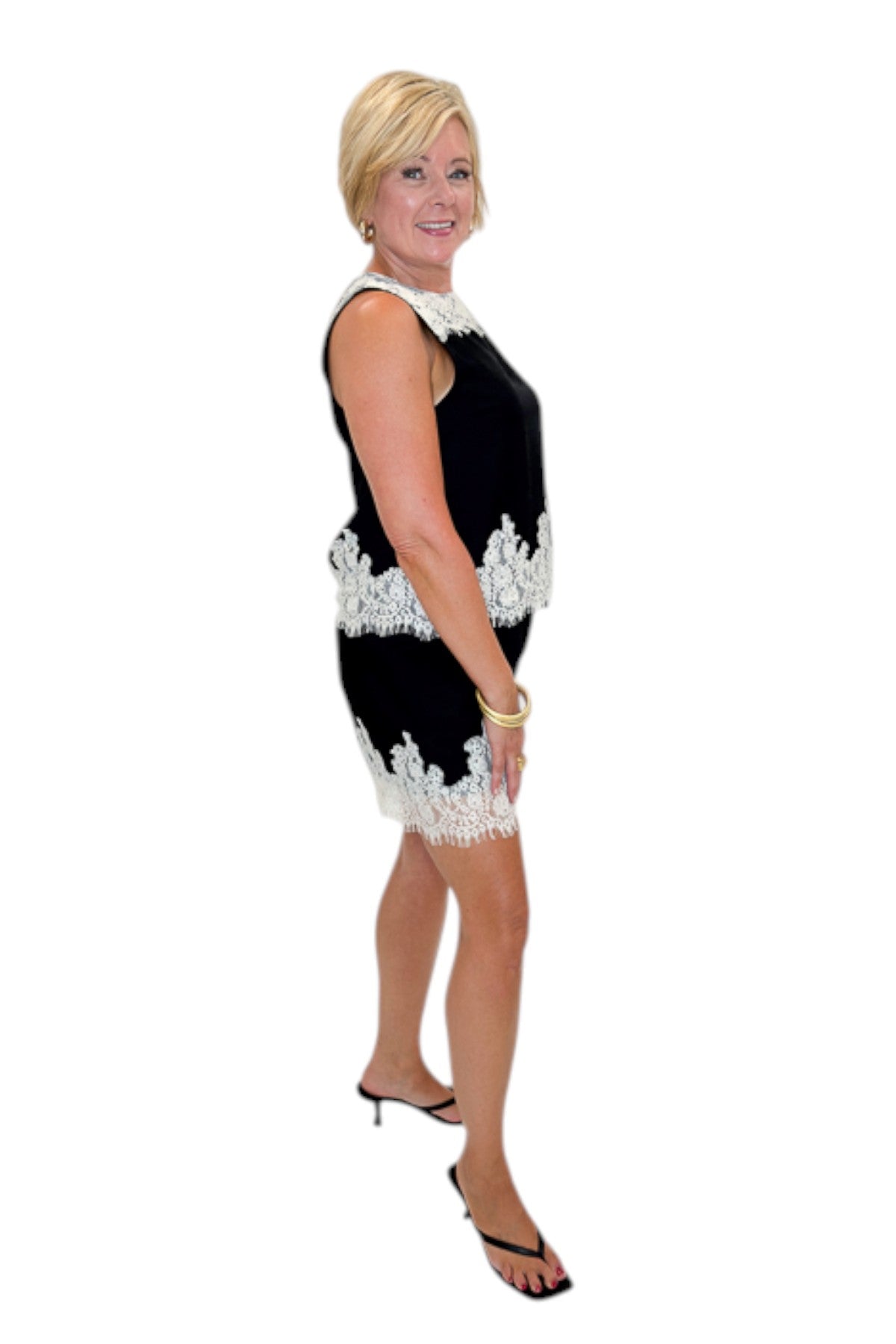 Side view of woman wearing Swagger Boutique’s Black &amp; Cream Lace Lined Tank with Black &amp; Cream Lace Lined Shorts by Entro against white studio background.