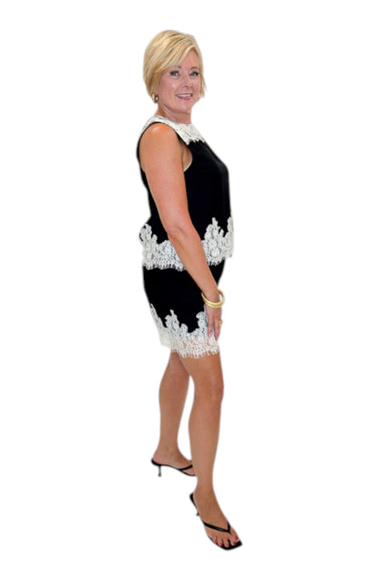 Side view of woman wearing Swagger Boutique’s Black &amp; Cream Lace Lined Tank with Black &amp; Cream Lace Lined Shorts by Entro against white studio background.