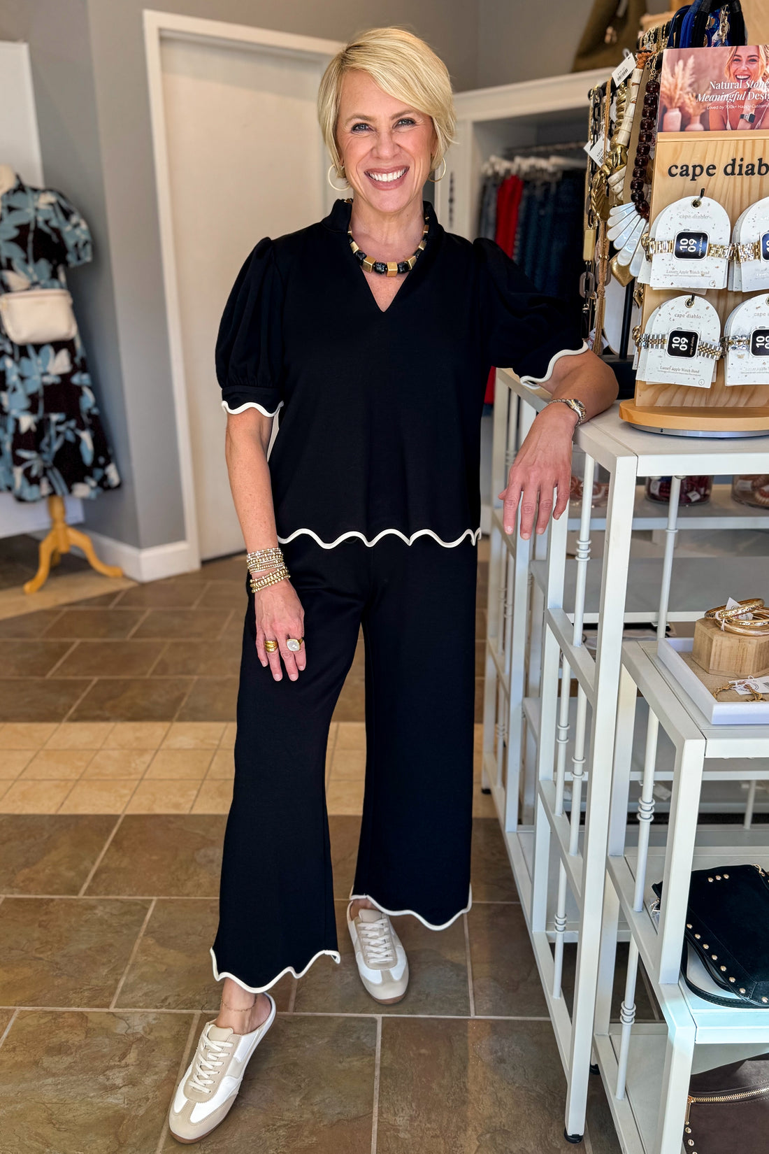Front view of woman wearing Swagger Boutique’s Black &amp; Cream Scalloped Top by Entro with matching Lounge Pants standing at the store.