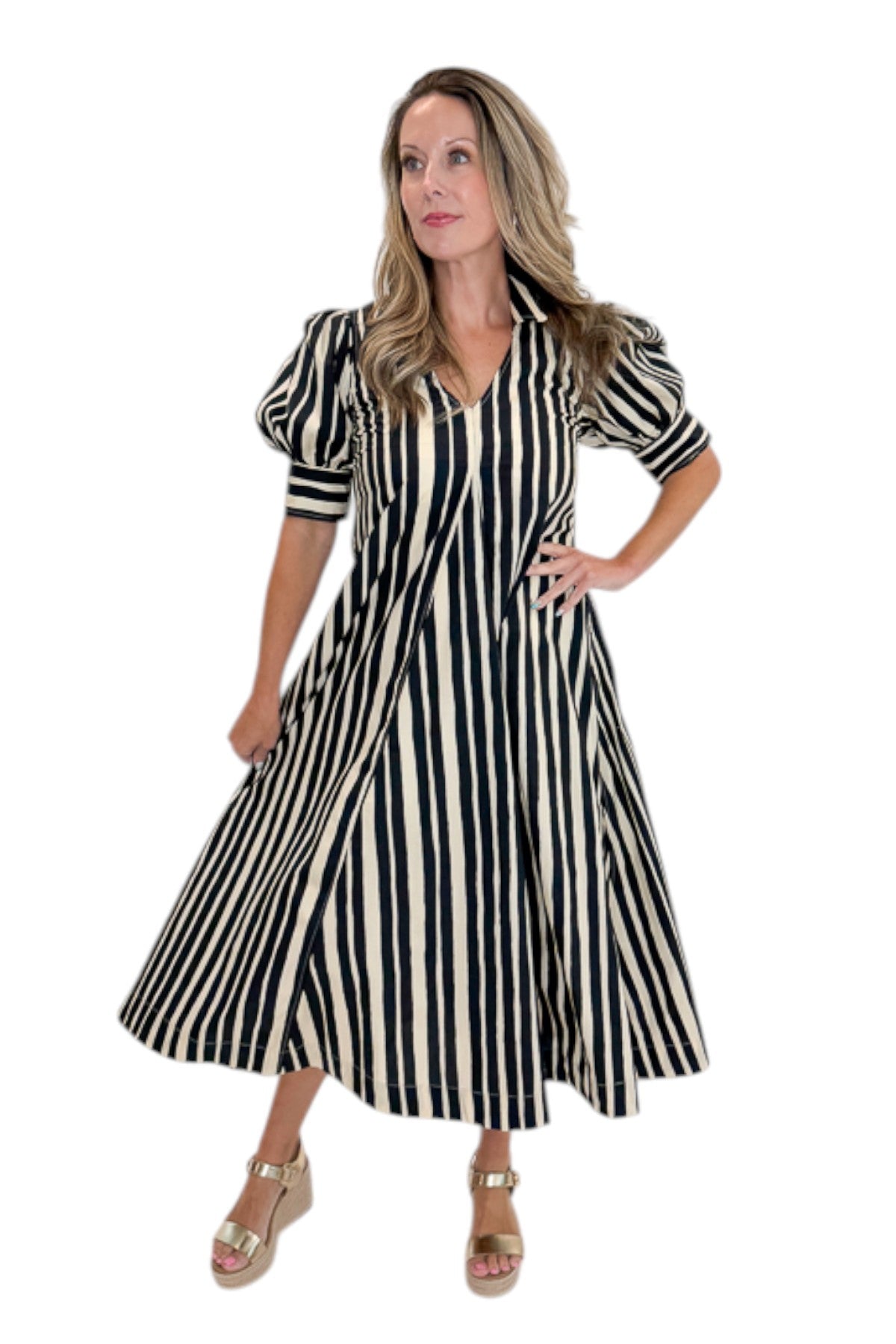 Front view of woman wearing Swagger Boutique’s Black &amp; Cream Striped Midi Dress with sandals against white studio background.