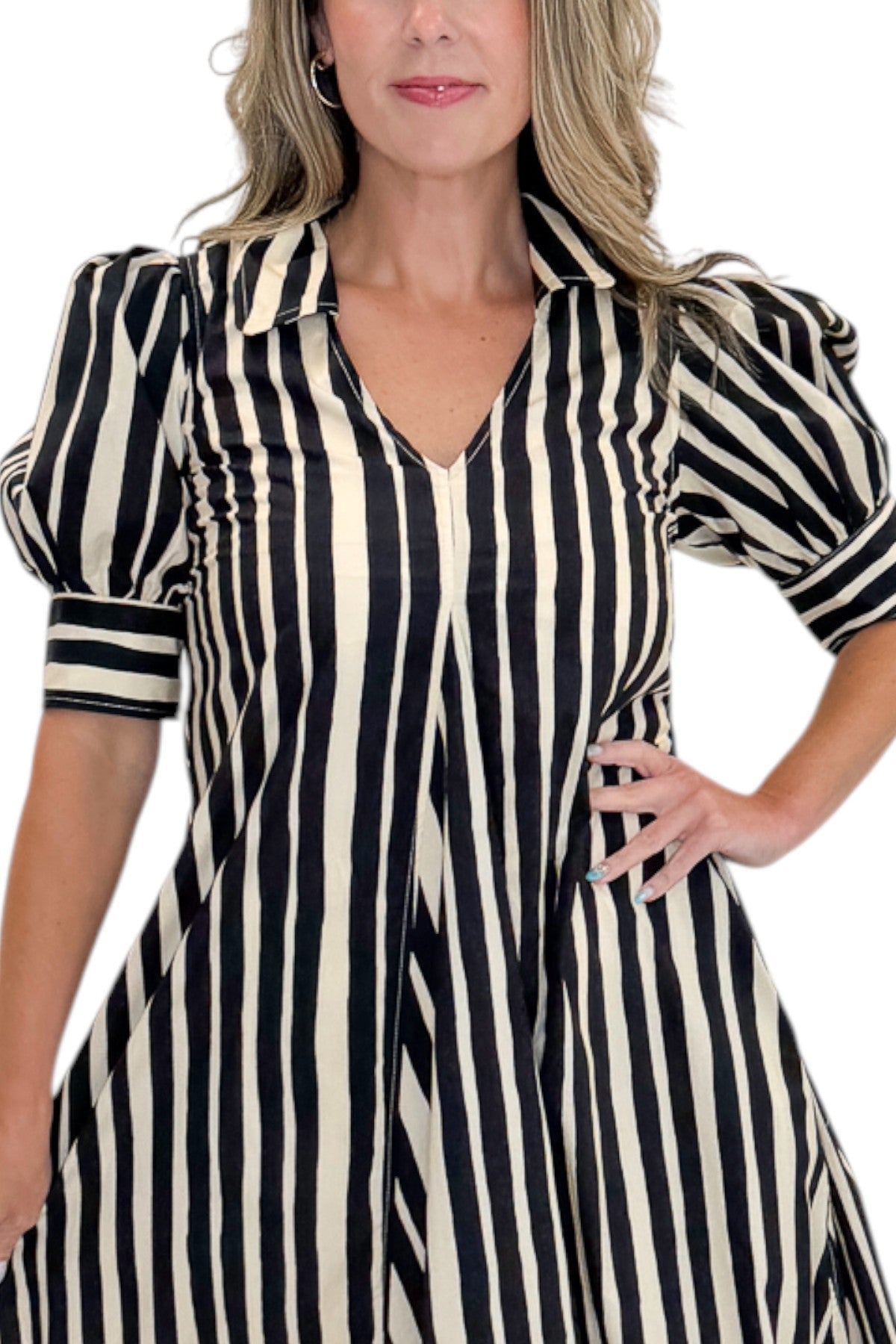 Front detail view of woman wearing Swagger Boutique’s Black &amp; Cream Striped Midi Dress with sandals against white studio background.