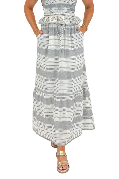 Front detail view of woman wearing Swagger Boutique’s Black &amp; Cream Striped Peplum Tank with matching tiered skirt against white studio background.