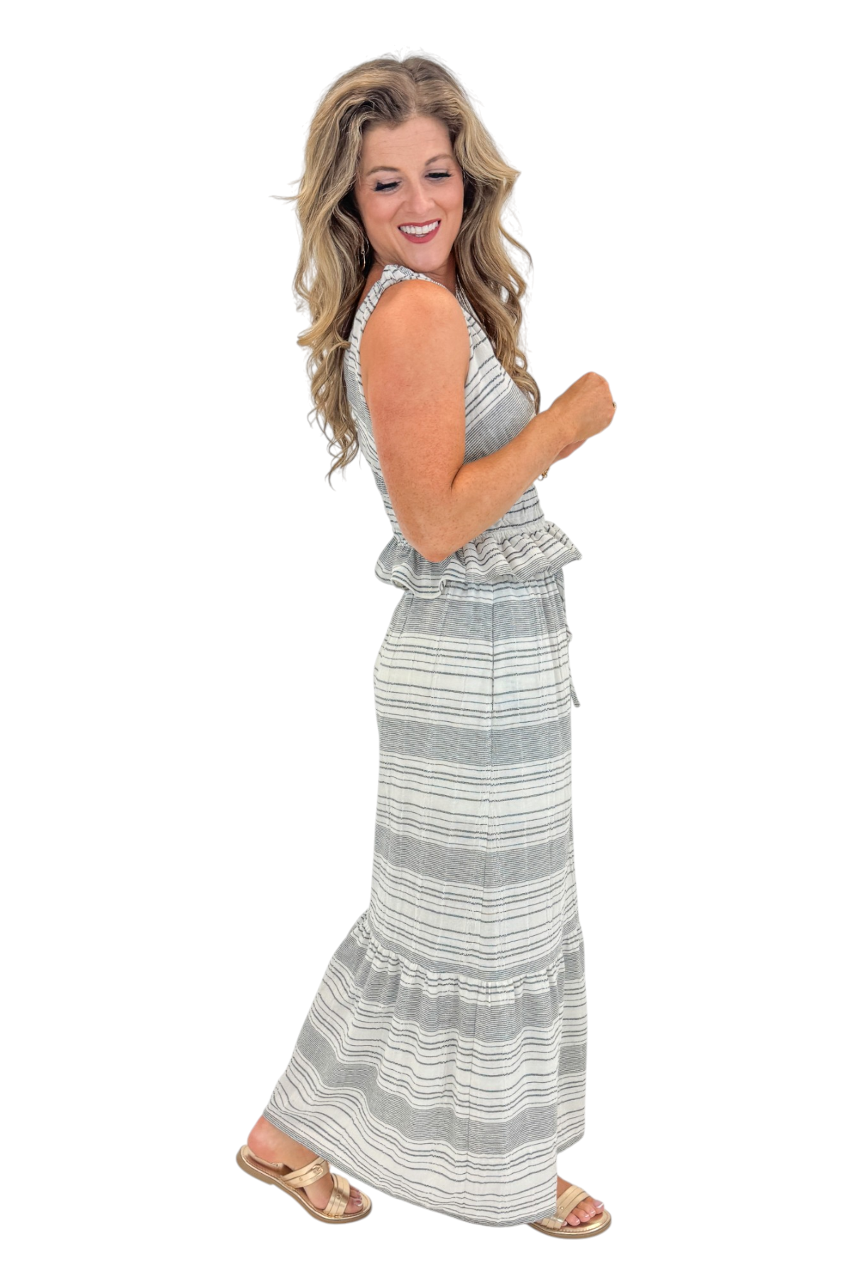 Side view of woman wearing Swagger Boutique’s Black &amp; Cream Striped Peplum Tank with matching tiered skirt against white studio background.