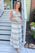 Front view of woman wearing Swagger Boutique’s Black & Cream Striped Peplum Tank with matching tiered skirt standing outside a house.
