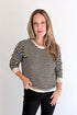 Front view of woman wearing Swagger Boutique’s Black & Cream Striped Sweater With Blue Accent with Kelsey Black Jeans against white studio background.