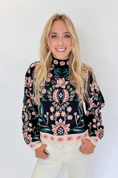 Front view of woman wearing Swagger Boutique’s Black &amp; Multi Floral Print Sweater by THML with jeans against white studio background.