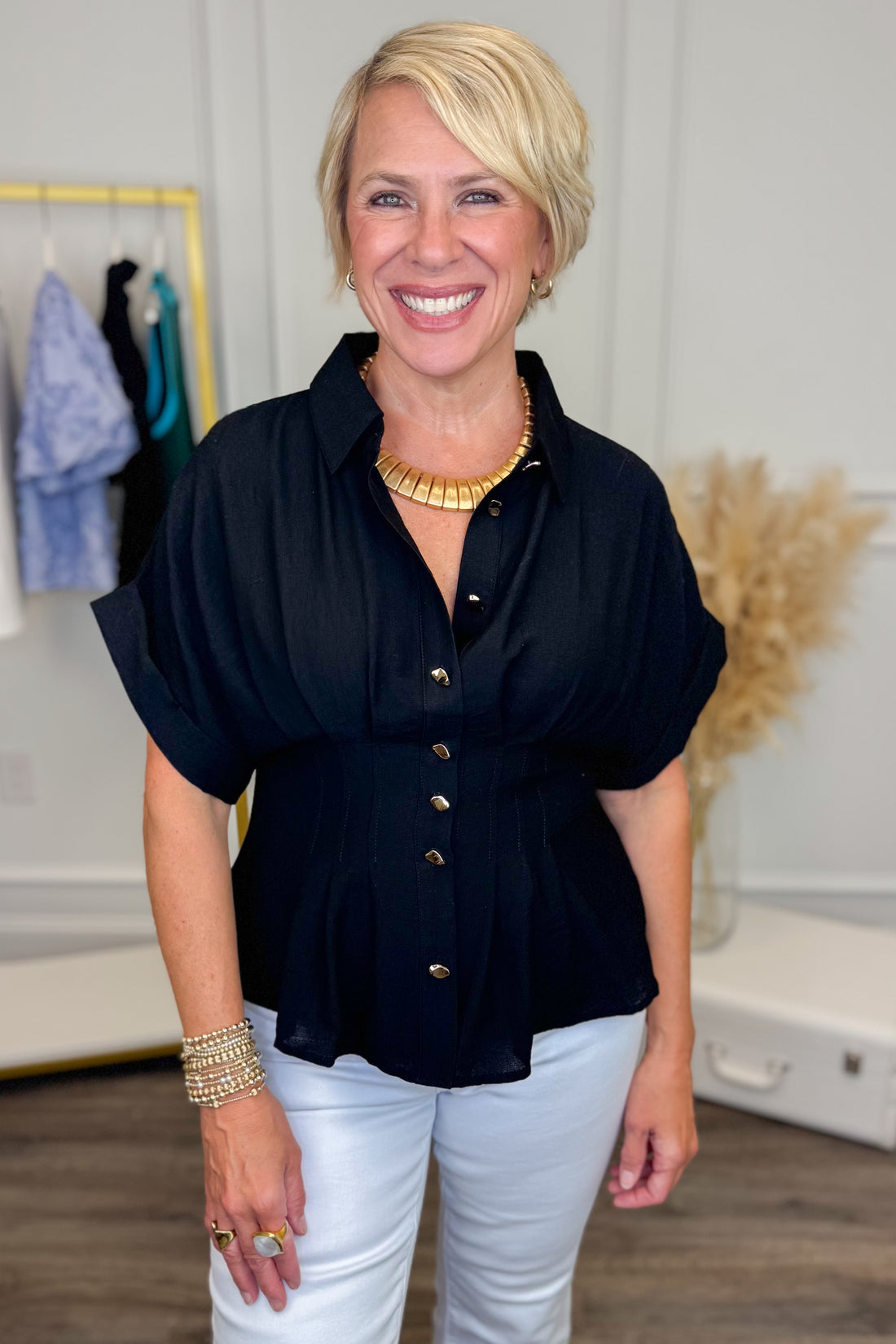 front close up view of woman wearing navy short sleeve collared top with white studio background 