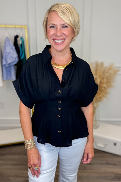 front close up view of woman wearing navy short sleeve collared top with white studio background 