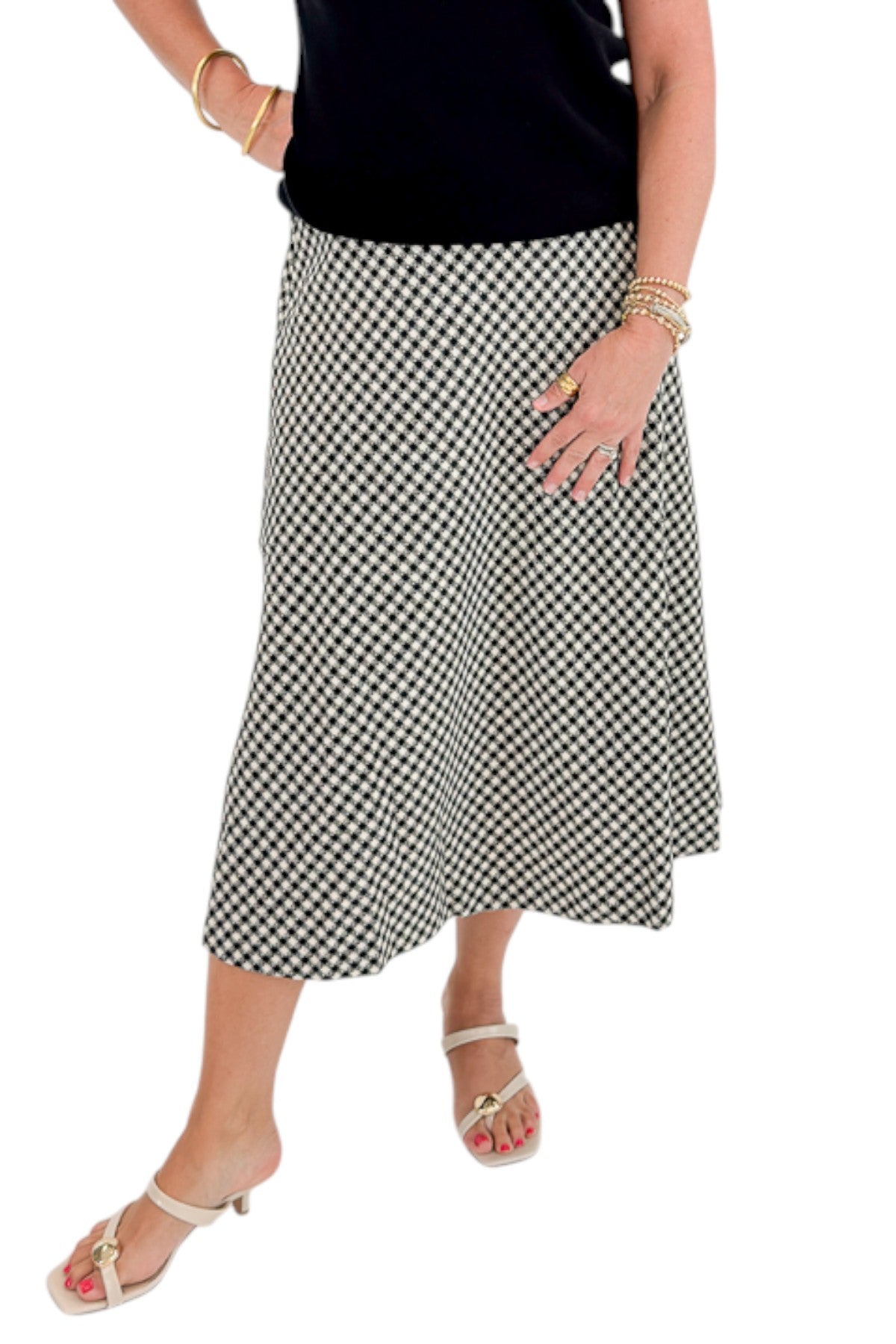 Front view of woman wearing Swagger Boutique’s Black Shirred Cap Sleeve Sweater with Black &amp; White Plaid Midi Skirt against white studio background.