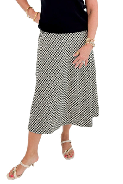 Front view of woman wearing Swagger Boutique’s Black Shirred Cap Sleeve Sweater with Black &amp; White Plaid Midi Skirt against white studio background.