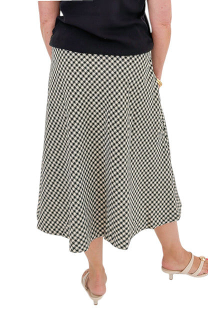Back detail view of woman wearing Swagger Boutique’s Black Shirred Cap Sleeve Sweater with Black &amp; White Plaid Midi Skirt against white studio background.