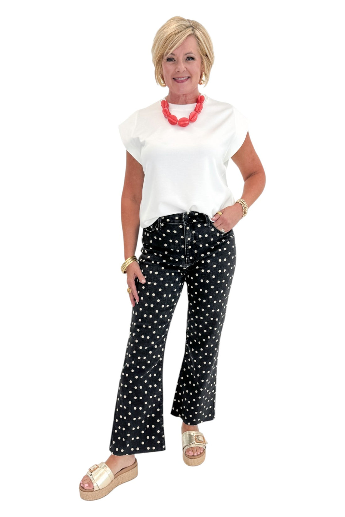 Front view of woman wearing Swagger Boutique’s Black &amp; White Polka Dot Crop Flare Jeans by Just Black Denim with top against white studio background.