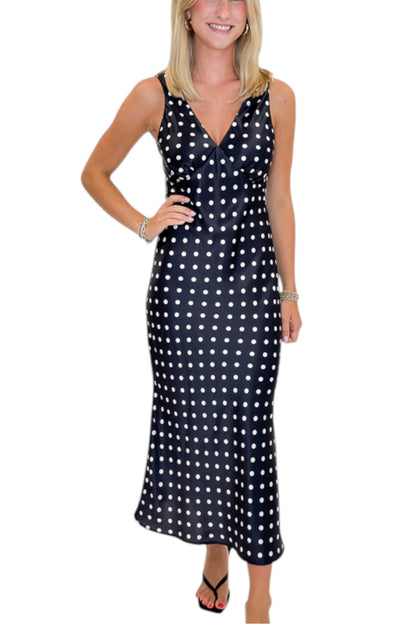 Front detail view of woman wearing Swagger Boutique’s Black &amp; White Polka Dot Satin Midi Dress with heels against white studio background.